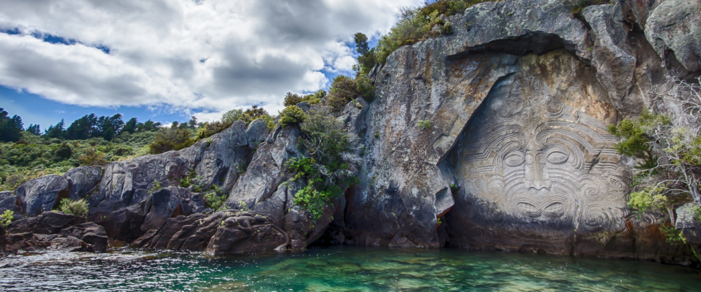 Māori stone carvings near a lake